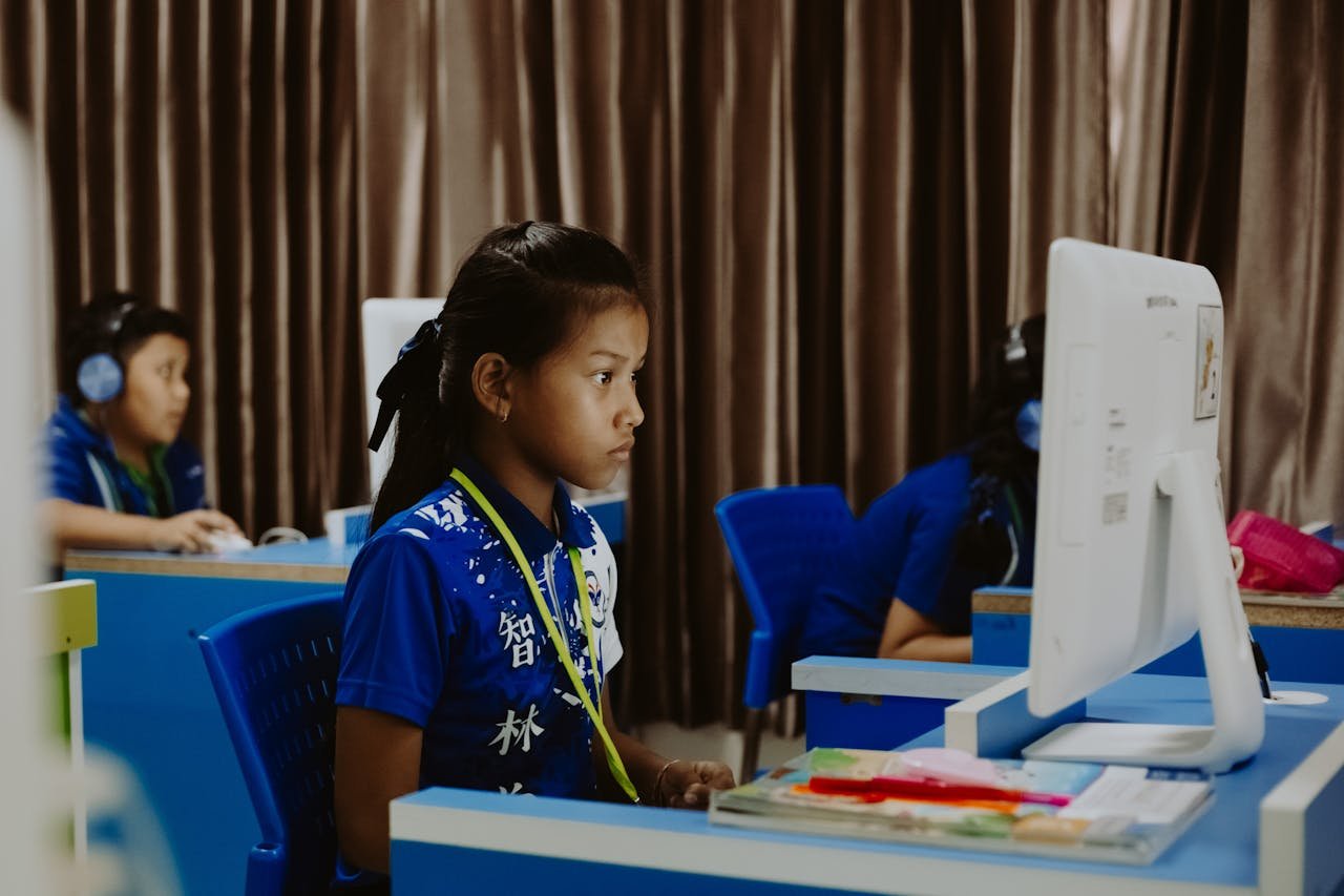 Young girls focused on learning in a computer lab, showcasing modern education.